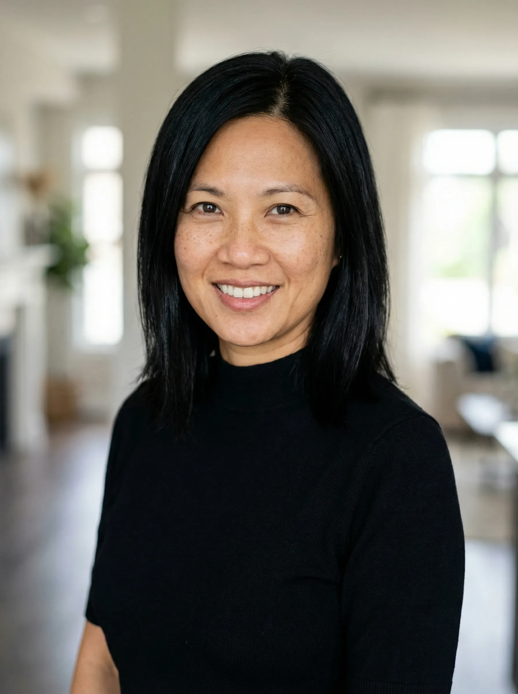 AI realtor headshot — woman in a black turtleneck in a modern luxury home